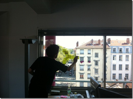 Cyril Plassard putting up Post-It Notes on his office window